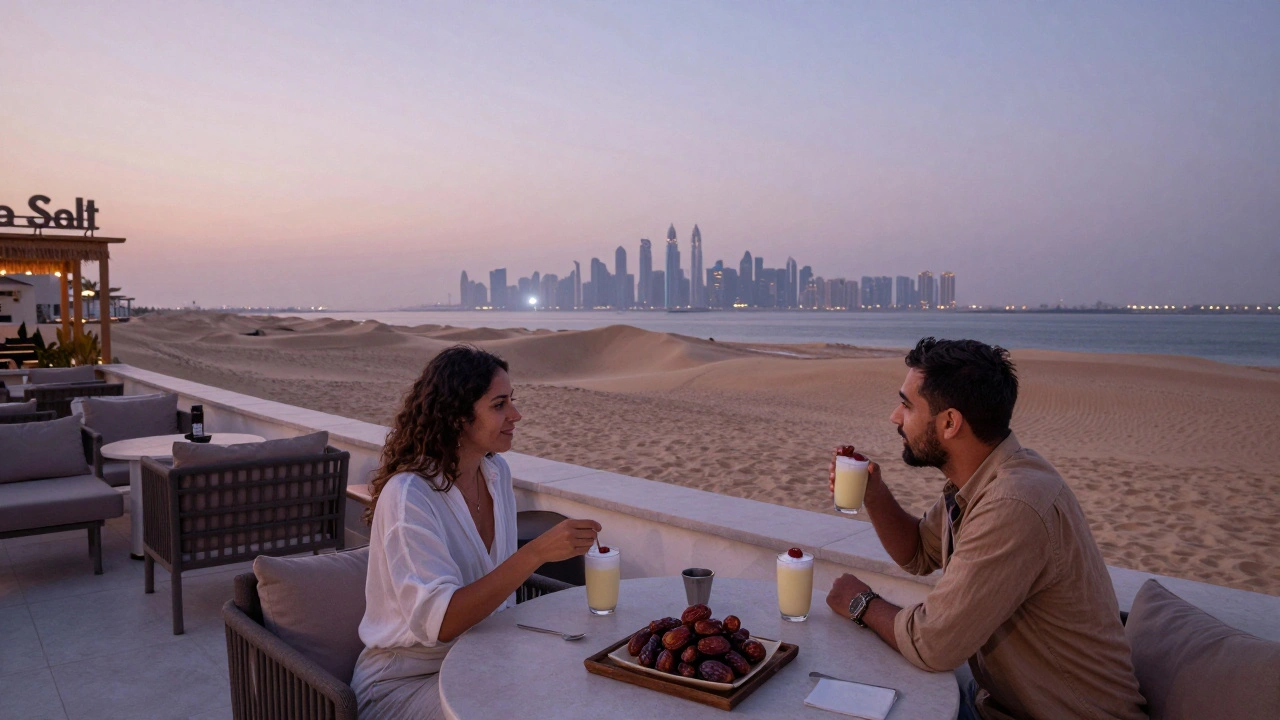 Quiet beach rooftop at dawn with two people enjoying drinks as Dubai’s skyline glows in the distance.